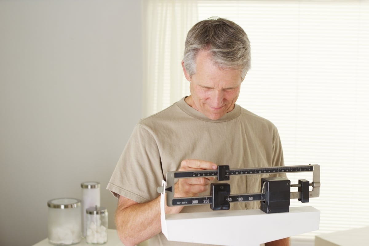 Man weighing himself after weight loss injections in salem va