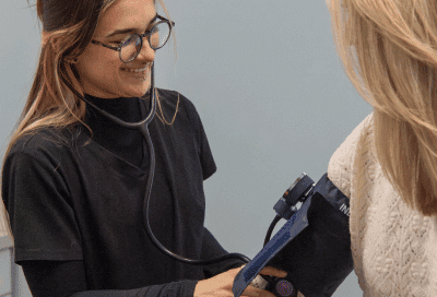 The weigh station medical staff member checking a patient's blood pressure, representing weight loss clinic 