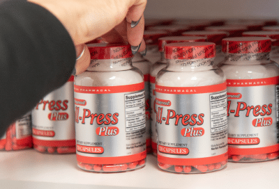 Hand reaching for supplement bottle, representing comprehensive weight loss program