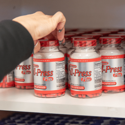 Hand reaching for supplement bottle, representing comprehensive weight loss program